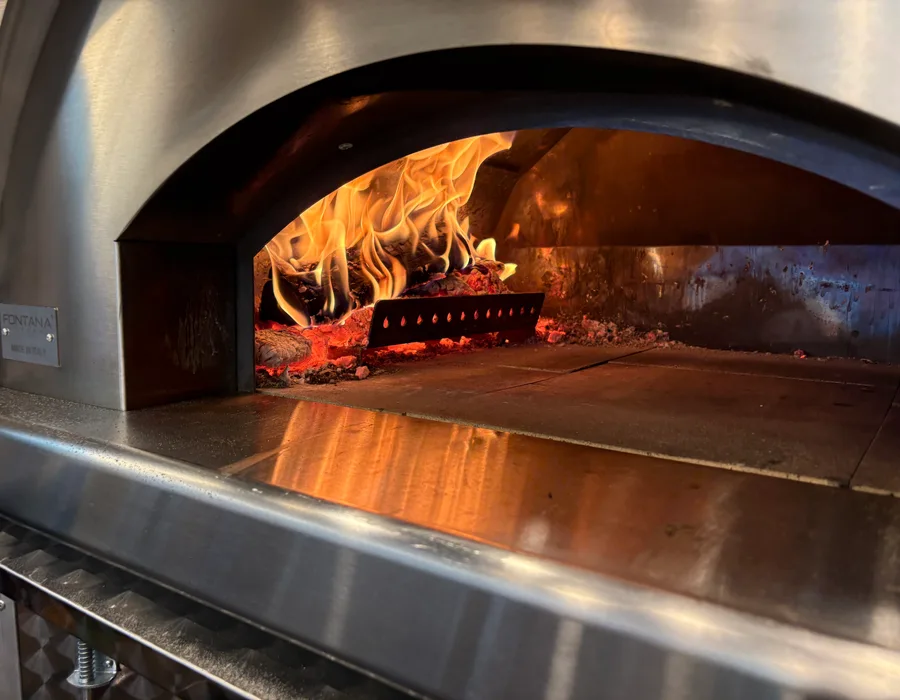 Flames glowing in Happy Pizza's wood-fired oven