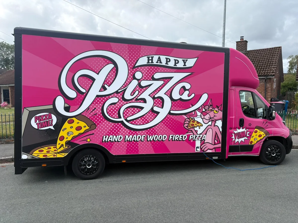 The real Happy Pizza van with bright pink pizza artwork